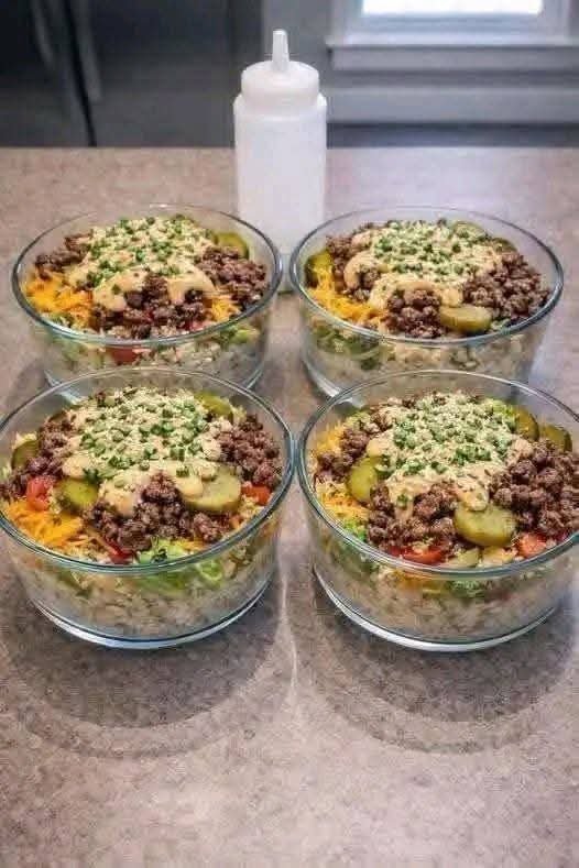 Cheeseburger Bowls with seasoned ground beef, rice, lettuce, tomatoes, pickles, cheddar, avocado, and creamy burger sauce